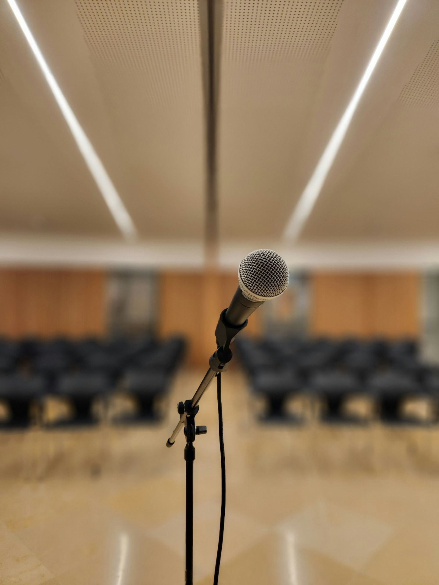 a microphone on a stand in front of a room full of chairs